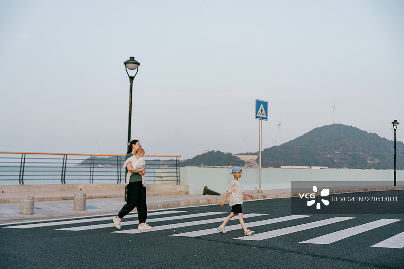 亚洲母亲在海滩上与孩子们玩耍；亚洲家庭生活方式图片素材