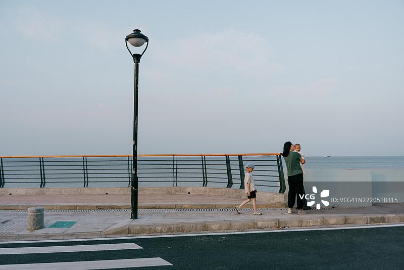 亚洲母亲在海滩上与孩子们玩耍；亚洲家庭生活方式图片素材