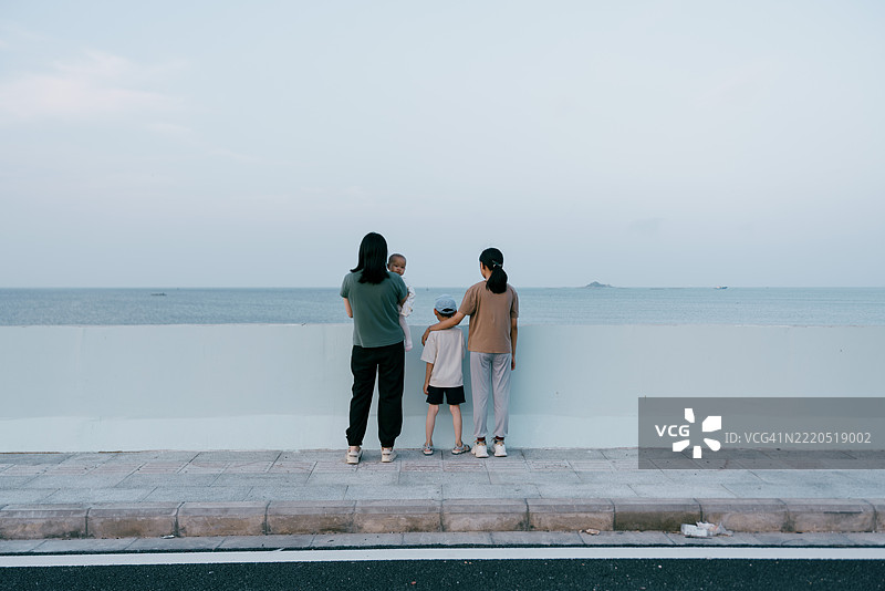 亚洲母亲在海滩上与孩子们玩耍；亚洲家庭生活方式图片素材