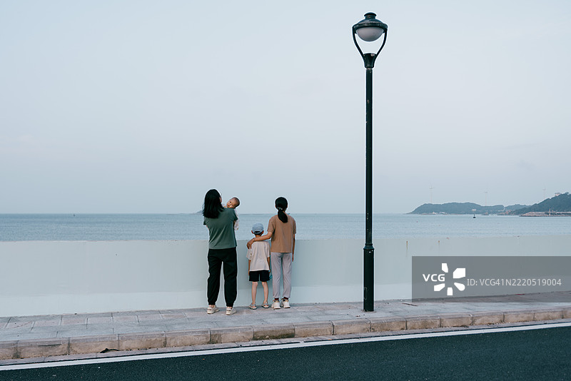 亚洲母亲在海滩上与孩子们玩耍；亚洲家庭生活方式图片素材