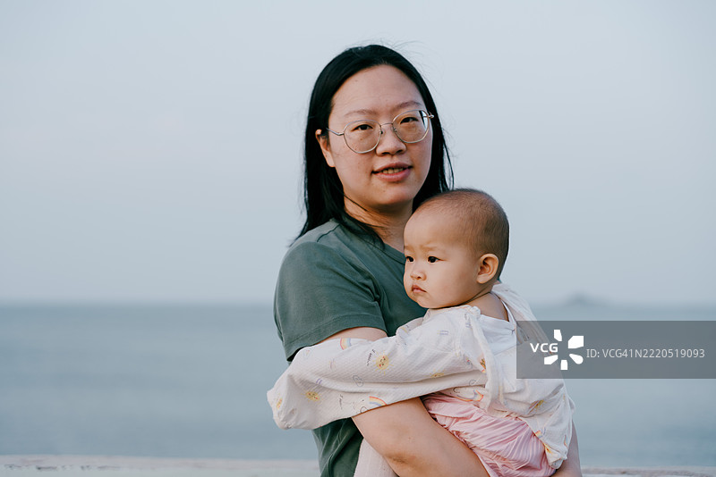 亚洲母亲在海滩上与孩子们玩耍；亚洲家庭生活方式图片素材