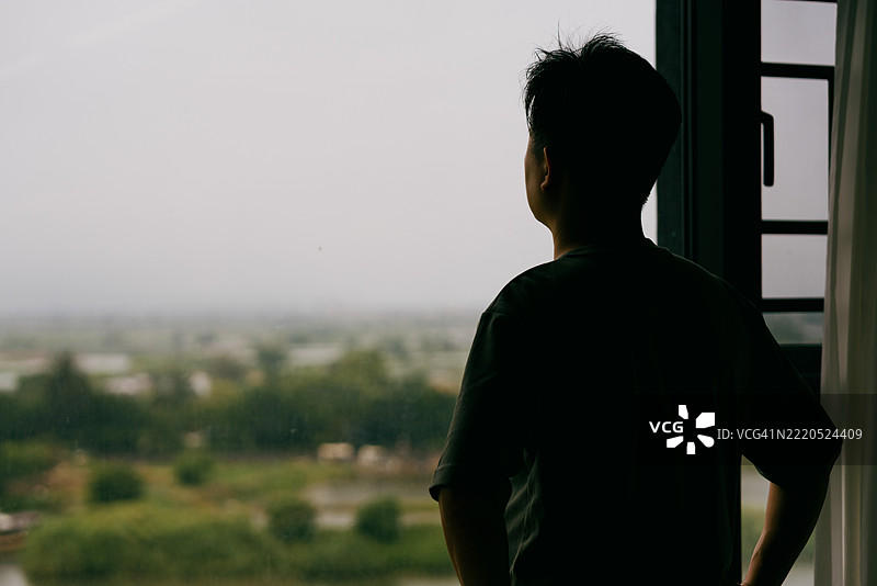 一位亚洲男子在阳台上欣赏风景；亚洲家庭生活方式图片素材