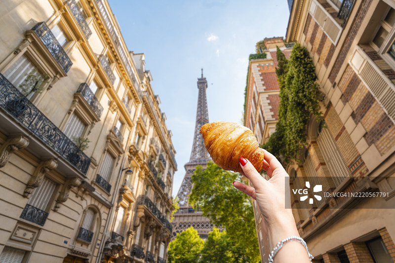 在法国巴黎埃菲尔铁塔前的女人手持可颂面包图片素材