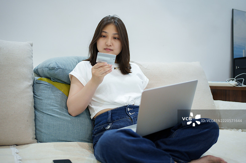 女性使用信用卡进行在线购物支付图片素材
