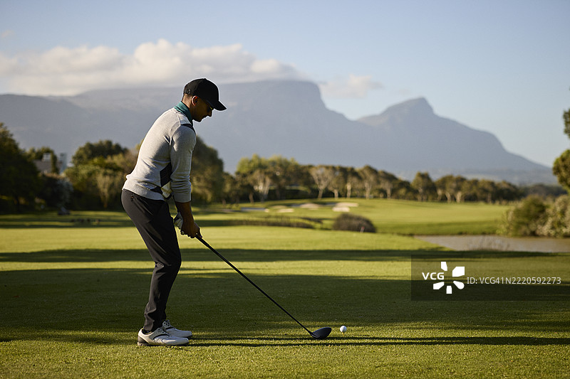 男性高尔夫球手在球场上挥杆击球图片素材