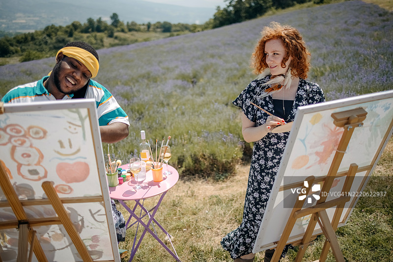 艺术学生在薰衣草田中一起绘画图片素材