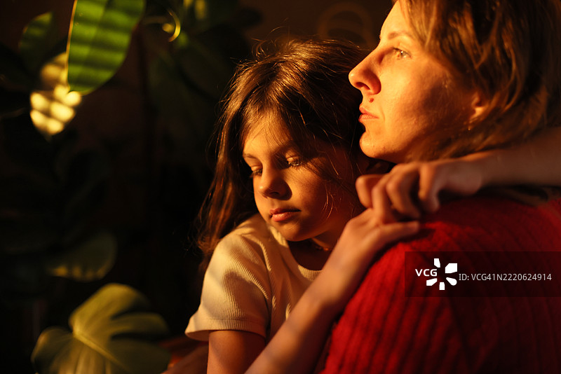 女儿在家中日落时分紧紧拥抱母亲的特写镜头图片素材