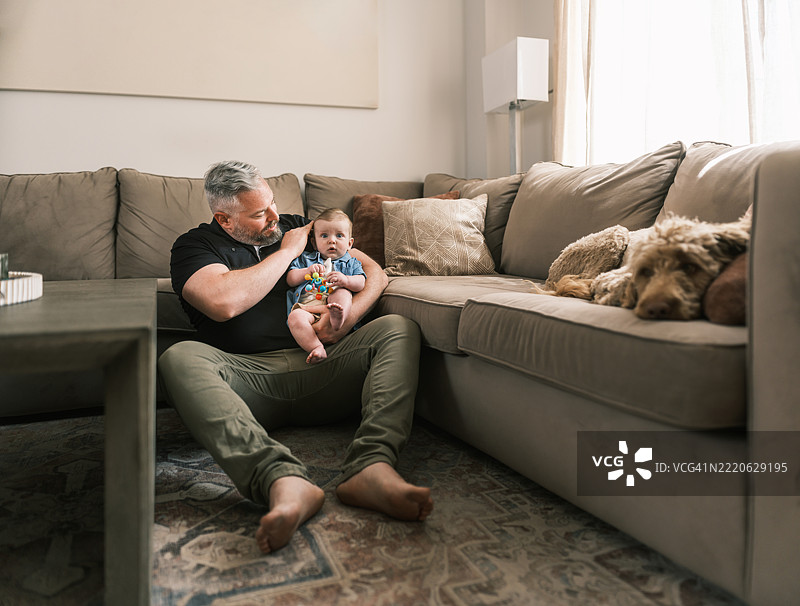 新爸爸在家和他的幼儿儿子玩耍图片素材