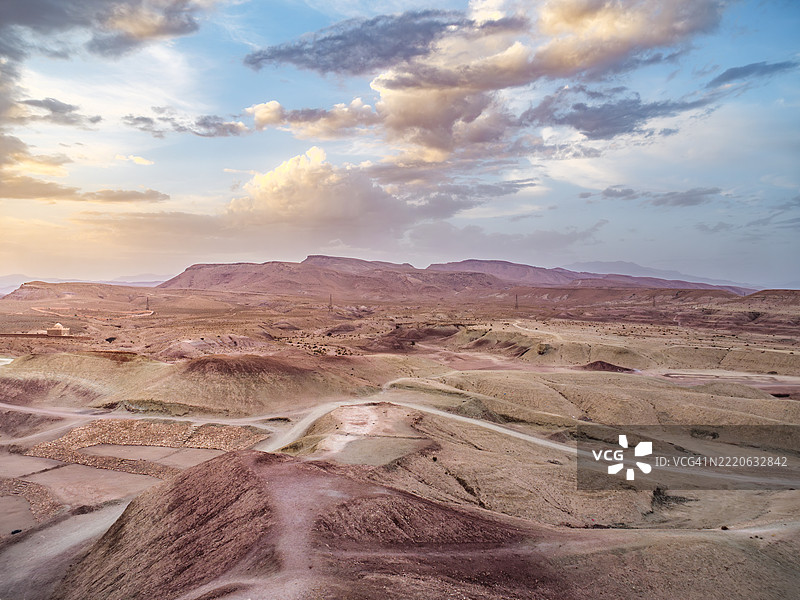 美丽的干旱起伏地貌，岩石形成，地质岩层，丘陵，山脉和日落时的徒步小径，靠近著名的柏柏尔人堡垒村阿伊特·本哈杜（Ait Benhaddou），联合国教科文组织世界遗产 - 瓦尔扎扎特 - 摩洛哥。图片素材