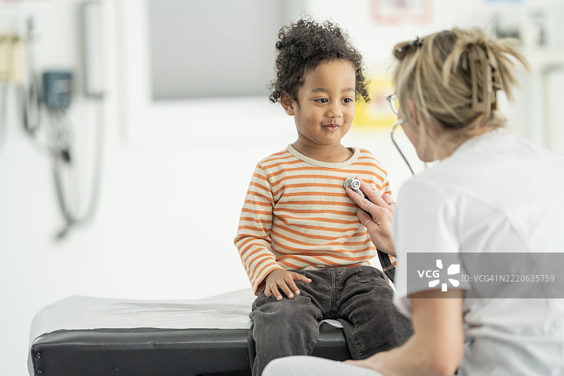 护士在明亮的诊所环境中检查年轻儿童的健康状况。图片素材