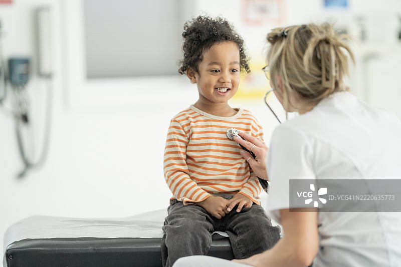 医生在诊所为快乐的孩子进行检查图片素材