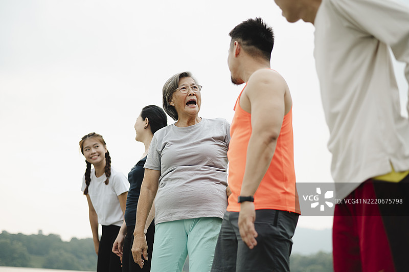 亚洲华人家庭在自然公园锻炼后休息和交谈。图片素材