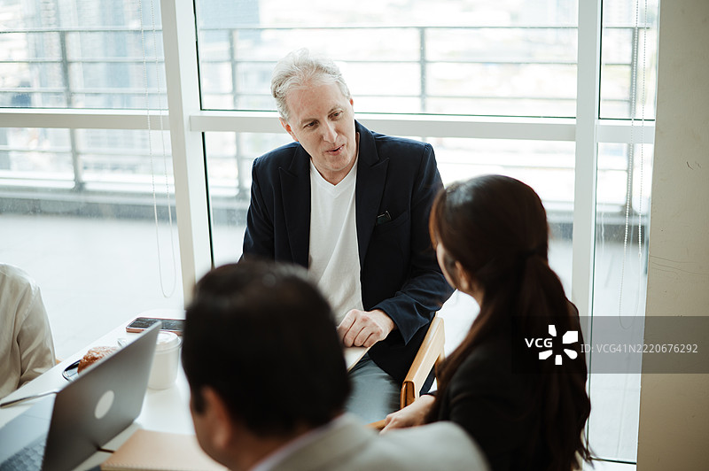 国际团队在享用早午餐时讨论工作图片素材