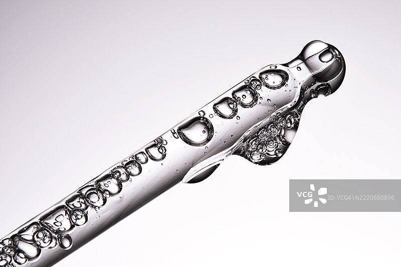 一支优雅的滴管，装有化妆品和大量气泡。精华液质地。图片素材