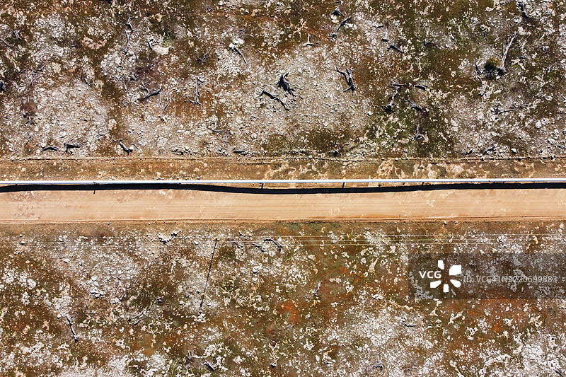 A water pipeline and access road in the sparse Australian countryside.图片素材