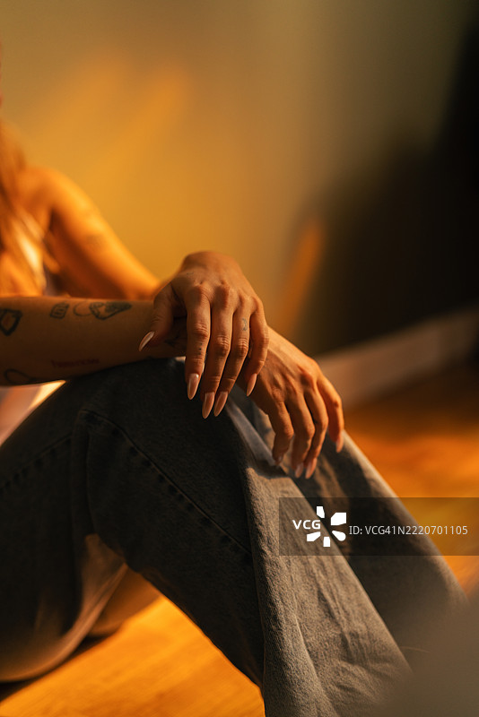 柔和光线下女人的手轻轻放在牛仔布上特写图片素材