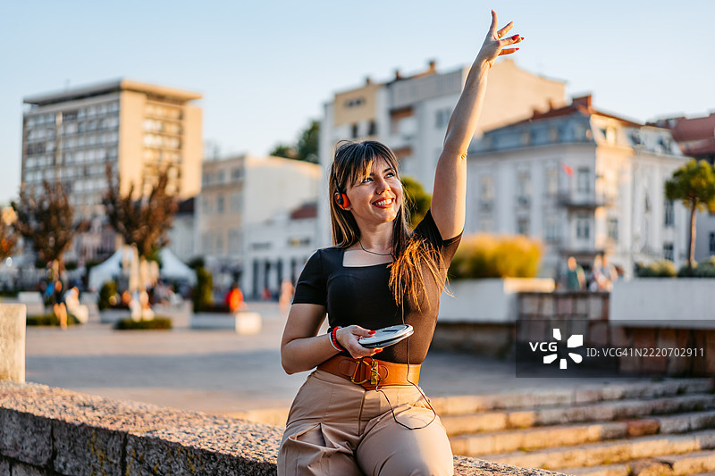 年轻女性在码头边用便携式CD播放器听音乐图片素材