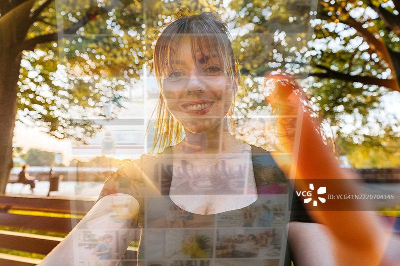 年轻女性坐在公园长椅上滑动社交媒体图片素材