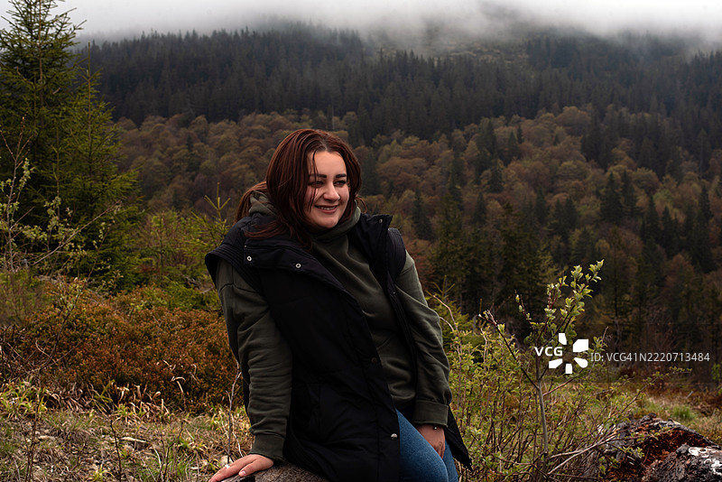 一位女性在山脉背景下的肖像。乌克兰喀尔巴阡山脉。年轻女性与自然的联系。心理健康。孤独。旅行。露营。山林旅游。图片素材