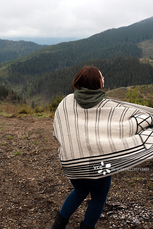 一位女性在山脉背景下的肖像。乌克兰喀尔巴阡山脉。年轻女性与自然的联系。心理健康。孤独。旅行。露营。山林旅游。图片素材