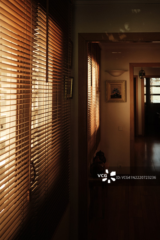 温暖的阳光透过木百叶窗洒在走廊上图片素材