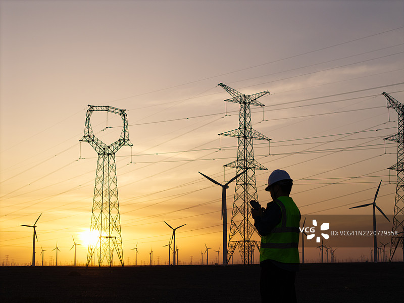 电力工人在日落时分工作场景图片素材