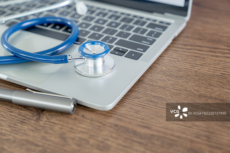 桌子上的听诊器和笔记本电脑，数字医疗和远程医疗的概念图片素材