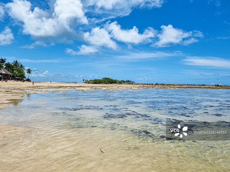 宁静的圣保罗山海滩，浅蓝色的海水、柔软的沙滩、棕榈树、乡村小屋和阳光明媚的天空——展现出纯粹海岸宁静的迷人瞬间。图片素材