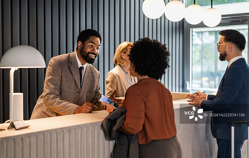 酒店接待员在登记处协助客人办理入住手续图片素材