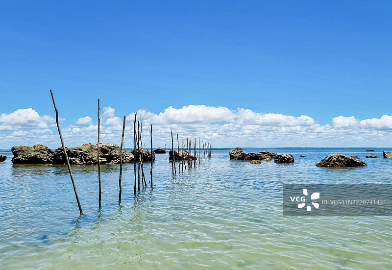 温柔的海浪轻吻着阳光照耀的岩石和风化的木桩，在圣保罗角，碧蓝的海水和明亮的天空孕育着宁静的海岸时刻。图片素材