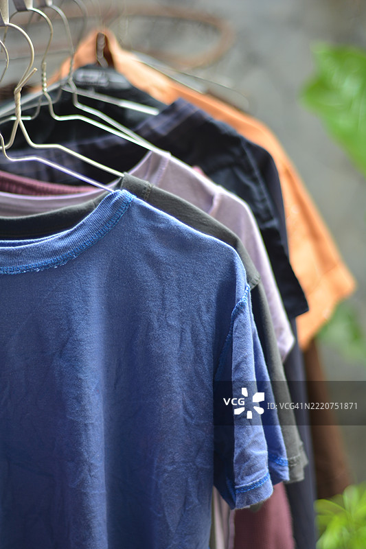 五颜六色的衬衫和裤子挂在晾衣架上晾干图片素材
