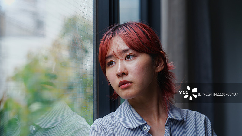 年轻女性站在窗边的感性肖像图片素材