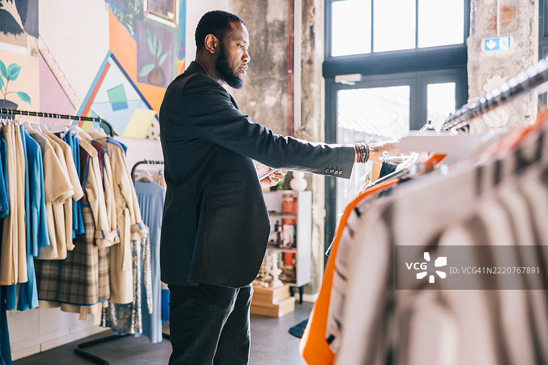 商人认真地浏览设计师服装架图片素材