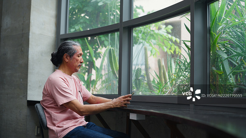 老年人在现代建筑中使用智能手机图片素材