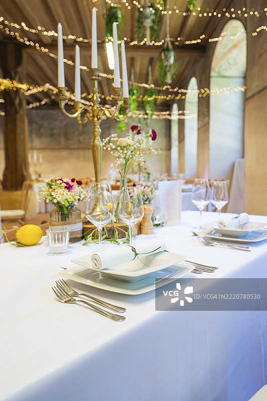 优雅的桌面装饰,搭配花卉和烛台,白色桌布营造出节日氛围,活动和婚礼场地:洛尔赫修道院,德国洛尔赫,欧洲图片素材