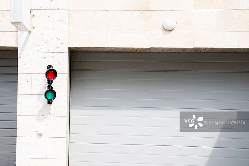 停车场入口的交通信号灯，背景是关闭的门，留白空间图片素材