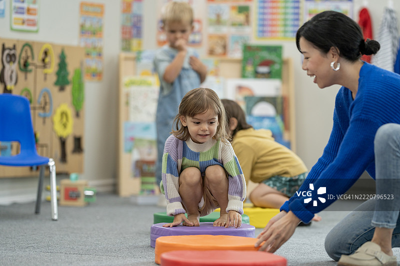 教师在充满活力的早期教育环境中与孩子们互动图片素材