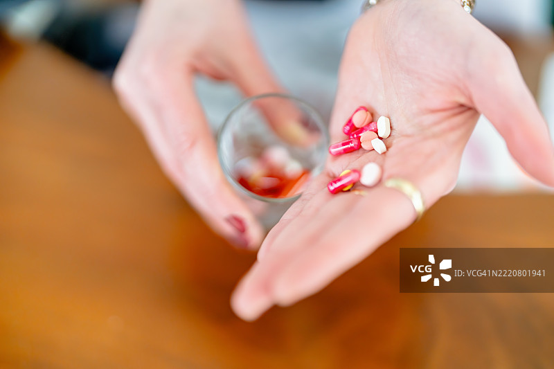 特写镜头展示手握各种颜色鲜艳的药物和药丸图片素材