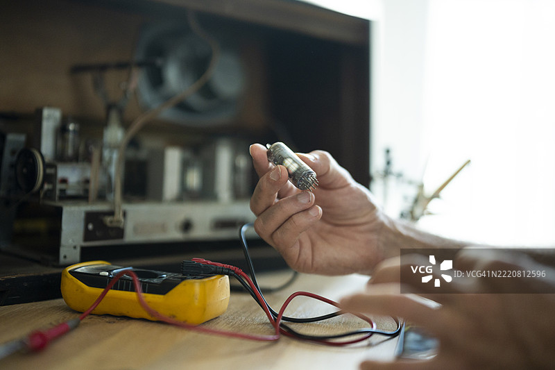 复古科技回归。一个人正在改造老式收音机。图片素材