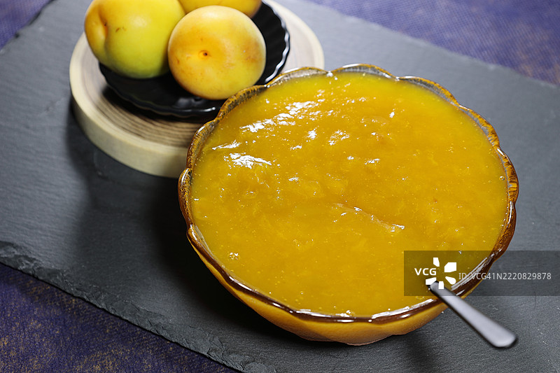 战争梅干和果酱调料，配勺子放在陶瓷盘上图片素材