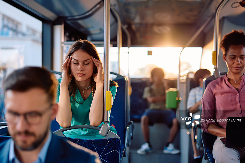 疲惫的护士在下班后感到头痛，乘坐公交车通勤图片素材