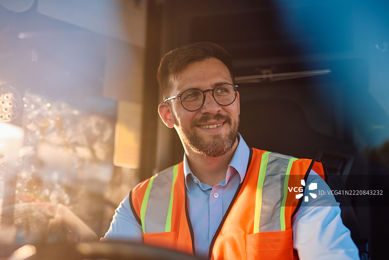 卡车司机在日落时微笑着驾驶图片素材