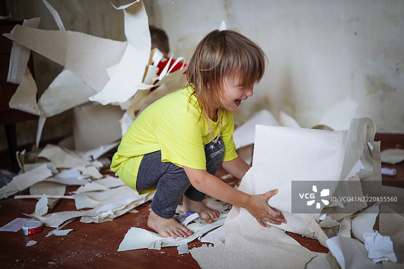 愉快的装修氛围：一个快乐的孩子在家居更新中创造温暖和快乐。图片素材