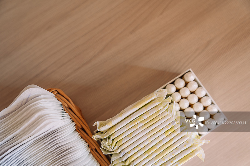 从上方看储存的生理期产品——卫生巾、棉条和月经杯——整齐且易于取用。可持续月经护理的简单视觉展示。图片素材