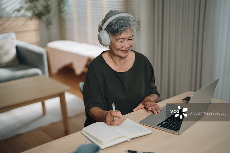 一位老年女性在家参加在线语言课程学习外语图片素材