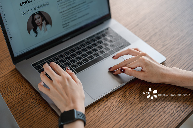 特写镜头：女性使用笔记本电脑更新简历以进行在线求职图片素材