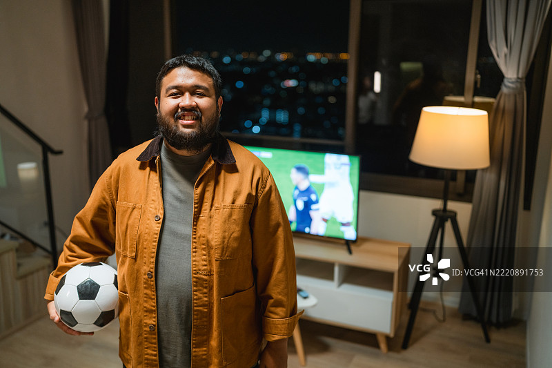 热情的足球迷肖像，兴奋的足球迷在家为比赛欢呼图片素材
