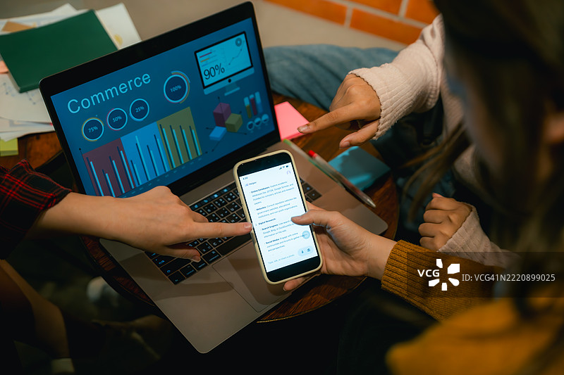 一群朋友围坐在智能手机旁，使用人工智能应用程序来帮助他们的团队项目。图片素材