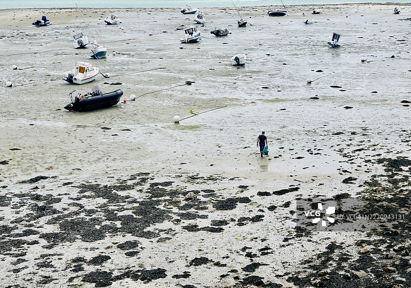 一名男子在2025年5月的低潮时走向他的船，地点是法国圣马洛。图片素材
