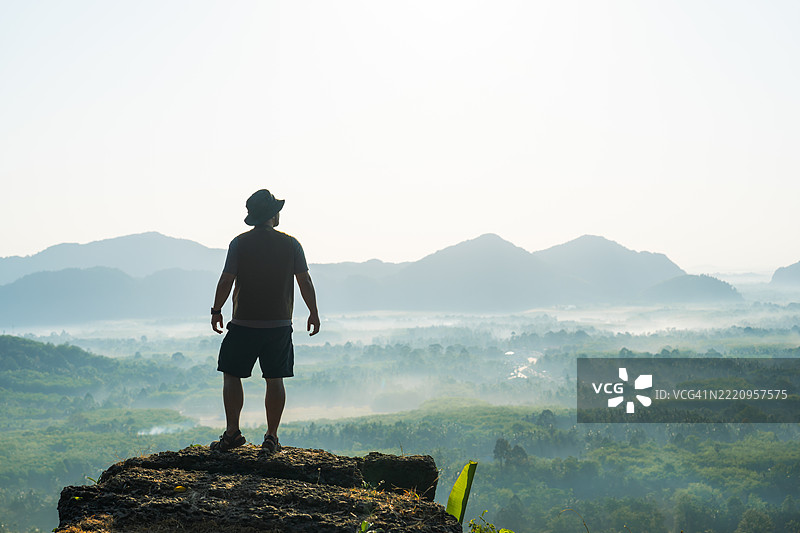一个站在悬崖上欣赏山景的男人图片素材